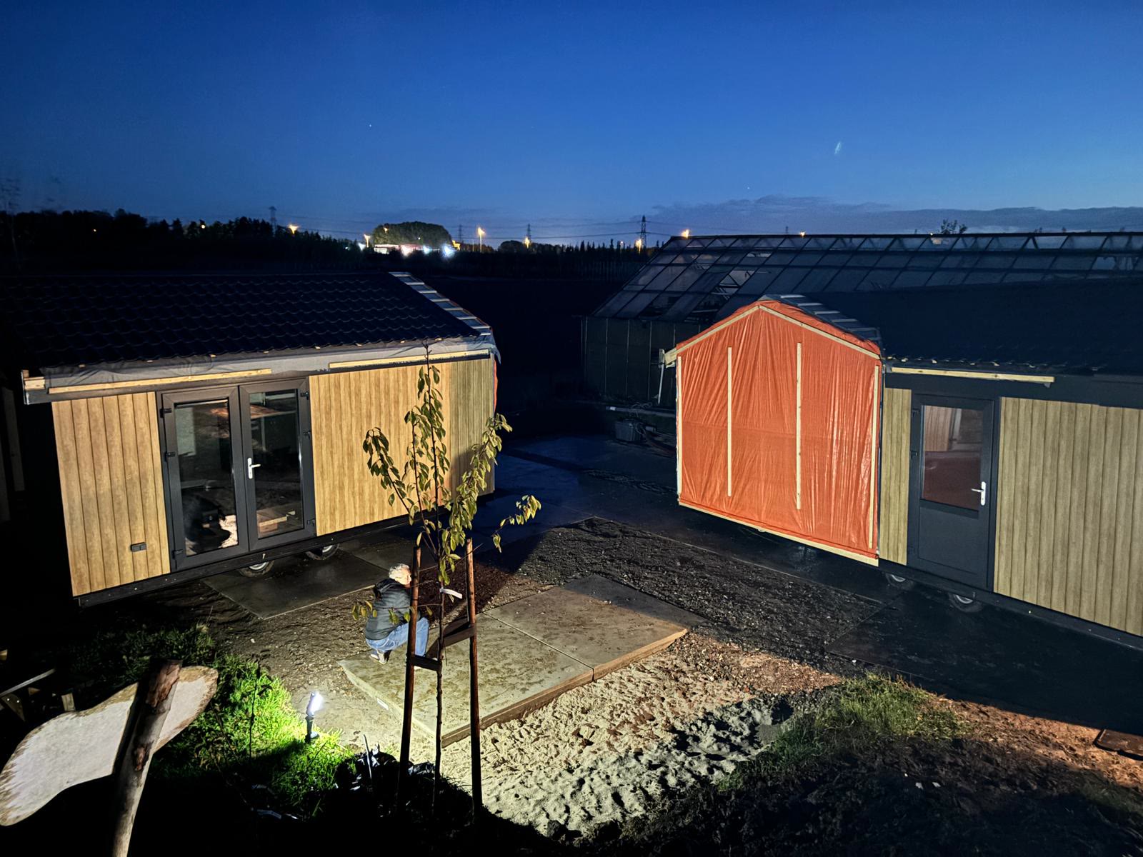 Twee geplaatste chalets op een nieuw park in de avond