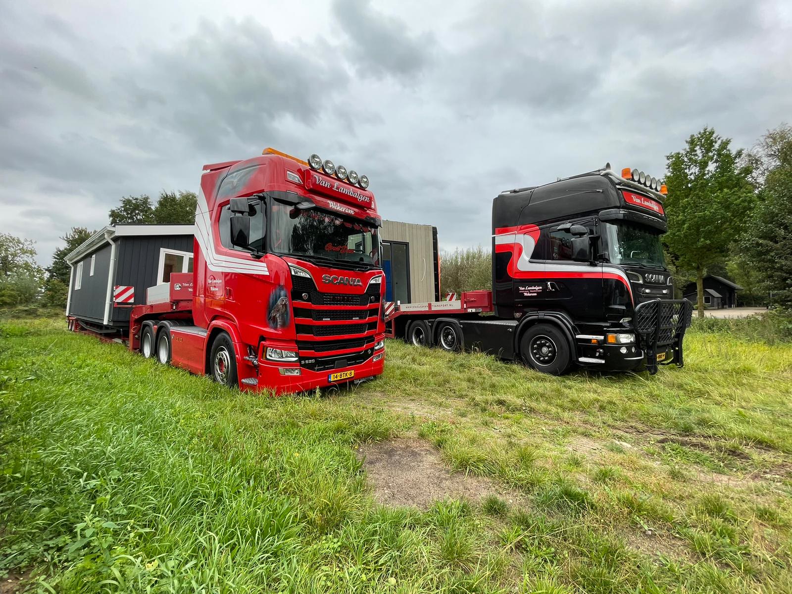 Twee trucks met moderne woningen op een grasveld