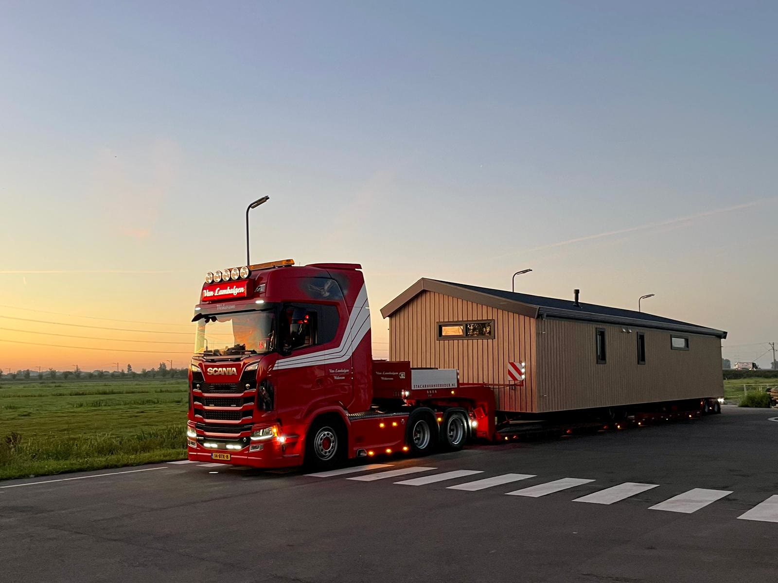 Truck met houten woning bij zonsondergang