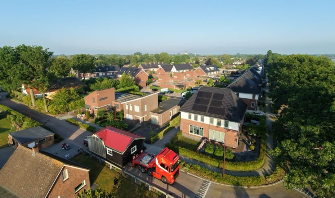 Luchtfoto van een dorpsstraat waar een rode truck met een woning staat